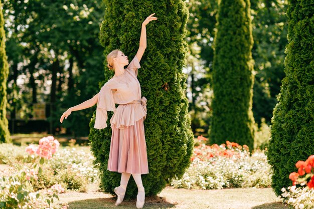 Chica hermosa bailarina posando con emoción dramática en el parque de verano.