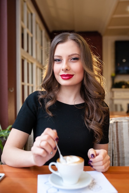 Una chica hermosa bebiendo café.