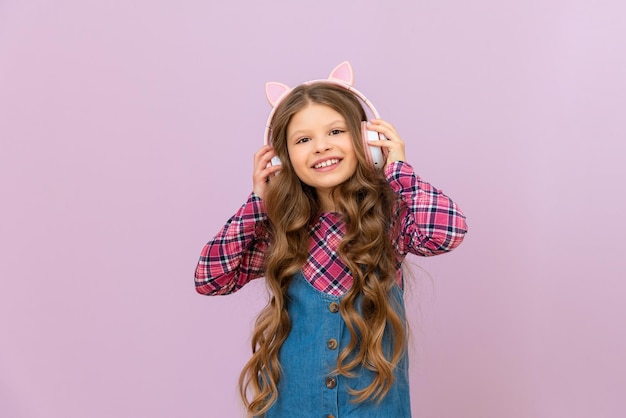 Una chica hermosa escucha un audiolibro con auriculares en un fondo aislado