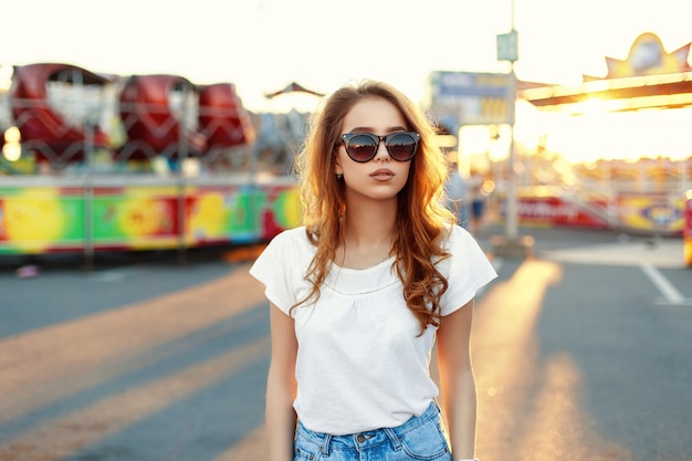 Chica hermosa con estilo en ropa de moda al atardecer