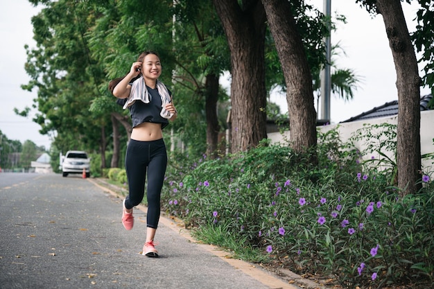 Chica hermosa feliz ejercicio jogging con fondo de árbol