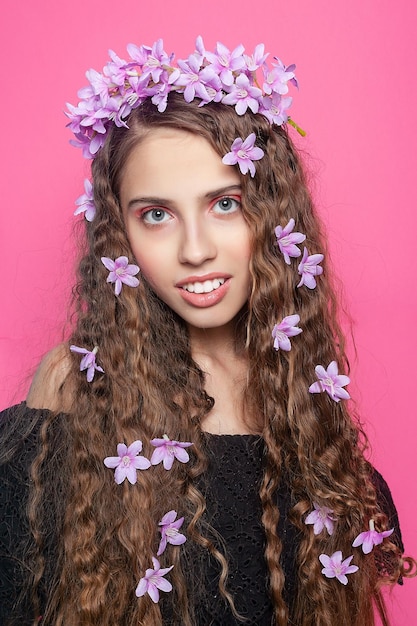 Foto una chica hermosa con flores en el cabello