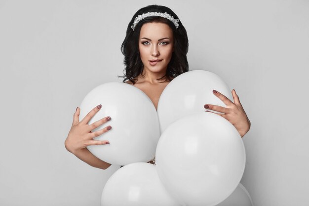 Chica hermosa modelo desnuda de moda con globos blancos