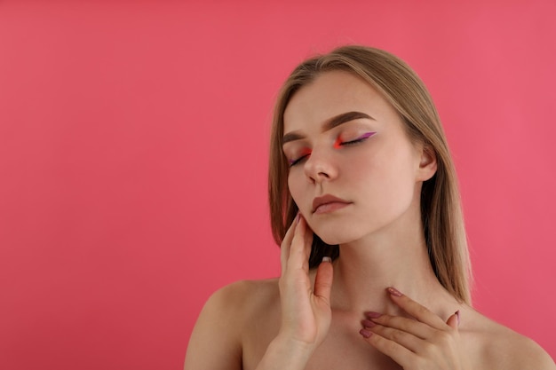 Chica hermosa modelo con maquillaje sobre fondo rosa