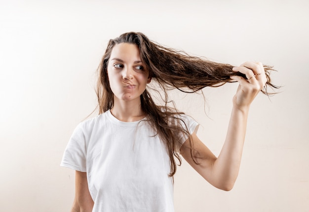 Chica hermosa mujer caucásica con húmedo desordenado duro después del baño. Problema de cabello fino. Aislado