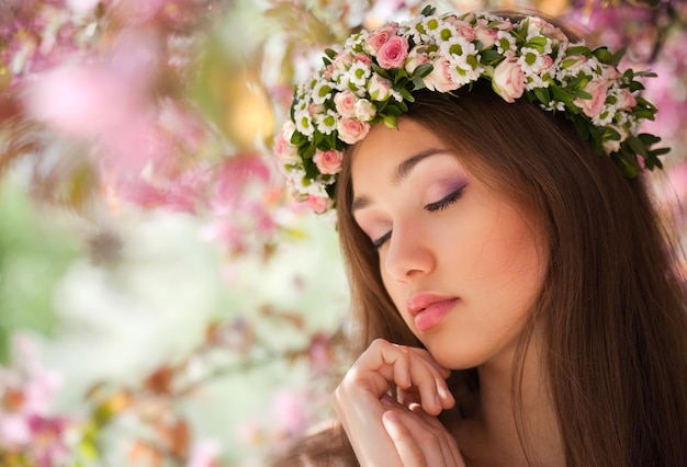 Una chica hermosa con los ojos cerrados y una corona de flores