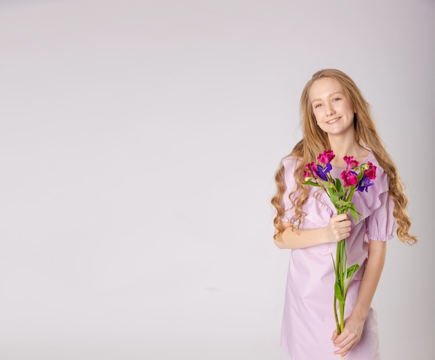 Chica con hermosas flores en ropa morada