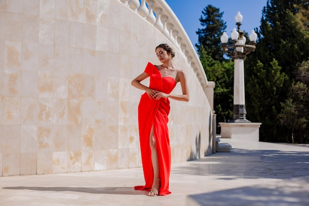 Chica con un hermoso vestido rojo elegante en el parque