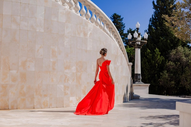 Chica con un hermoso vestido rojo elegante en el parque