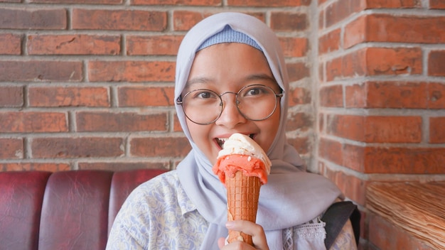 Chica hijab asiática mientras disfruta de un helado de gelato