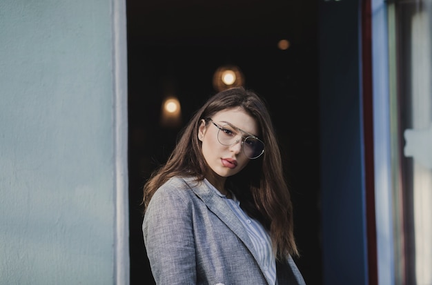 Chica hipster en chaqueta posando en la calle de la ciudad. Mujer joven con aspecto elegante.