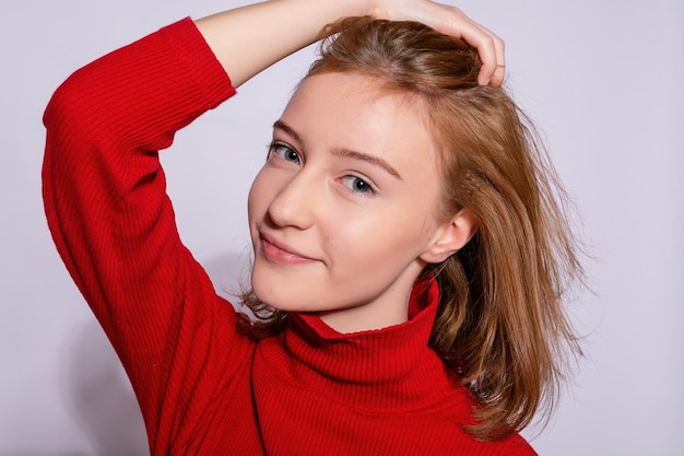 Chica hipster hermosa de moda Foto de una mujer agradable joven positiva en rodillas amarillas con fondo blanco