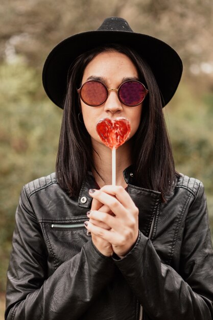 Chica hipster de moda con piruleta roja