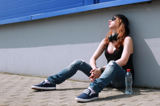 Chica hipster en la pared azul