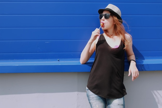 Chica hipster en la pared azul