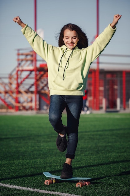 Foto chica hipster con patineta al aire libre chica moderna con patineta caminando en un estadio descanso del estudio aire libre estilo de vida