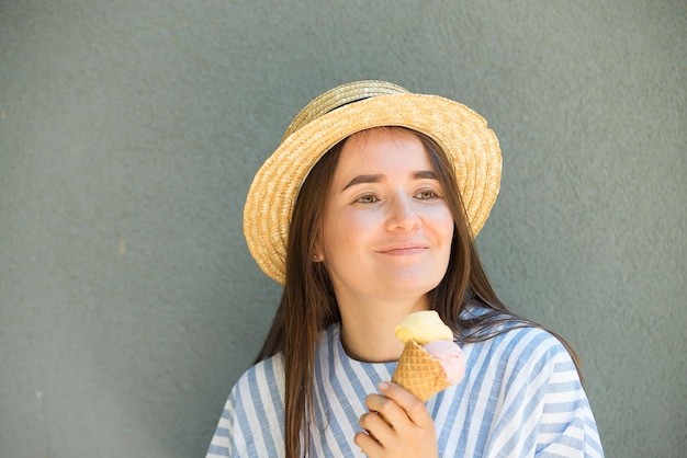 Chica hipster con sombrero de paja está comiendo helado