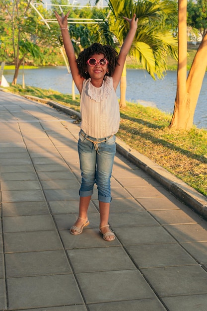 Chica hispana jugando en el parque en el patio de recreo