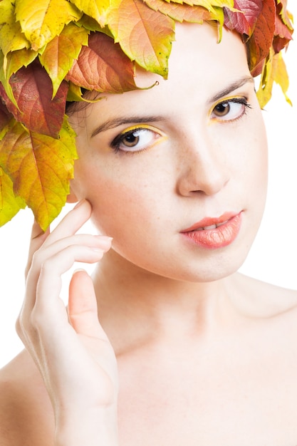 Chica con hojas de otoño en la cabeza.