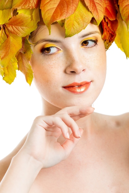 Chica con hojas de otoño en la cabeza.