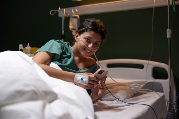 Una chica en el hospital juega juegos en su teléfono está enferma y necesita ayuda para mejorar