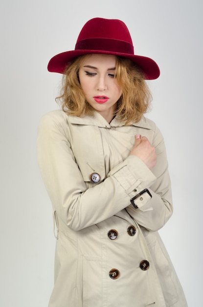 Chica con impermeable y sombrero.