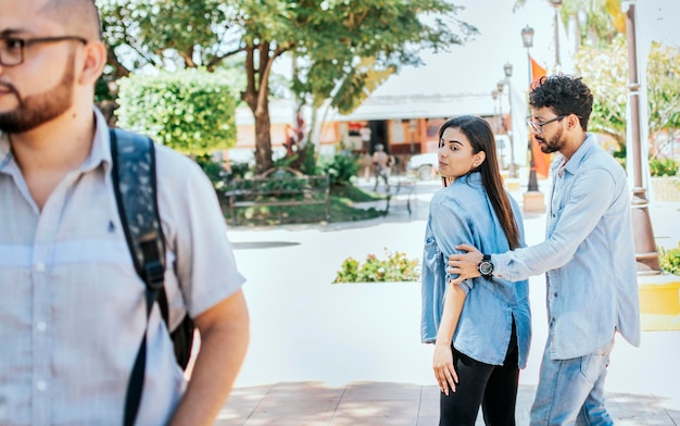 Chica infiel mirando a otro hombre en la calle mientras su novio la reclama Novia desleal mirando a otro hombre en la calle Novia infiel mirando a otro hombre en la calle