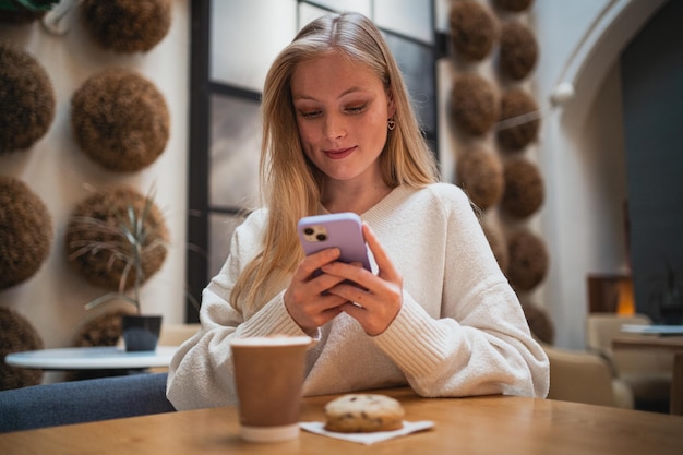 Chica influencer tomando una foto de su café para compartirla con sus seguidores en las redes sociales