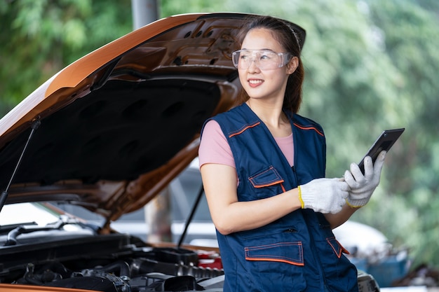 Chica ingeniera mecánica trabajando en un vehículo en un garaje o servicio wo