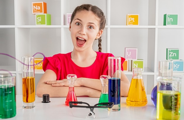 Chica inteligente durante la lección de química en la escuela