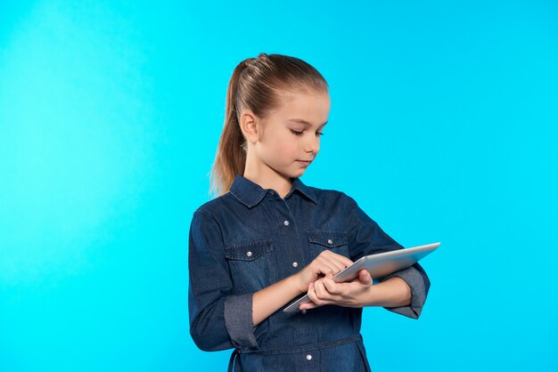 Chica interactúa con la tableta de la computadora