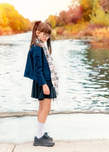 Chica en jaket glassess y falda en el bosque de otoño que parece una chica de anime
