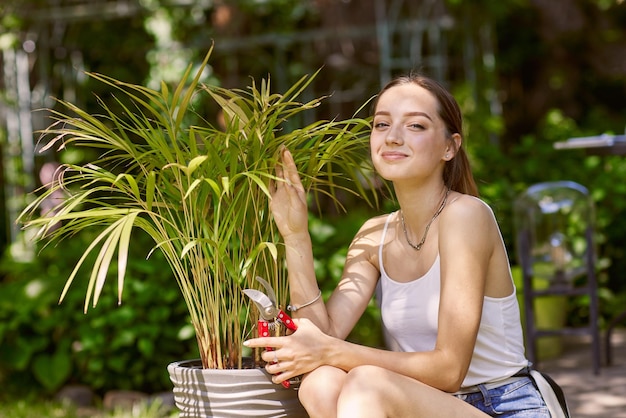 Chica jardinero cuidando plantas con una sonrisa.