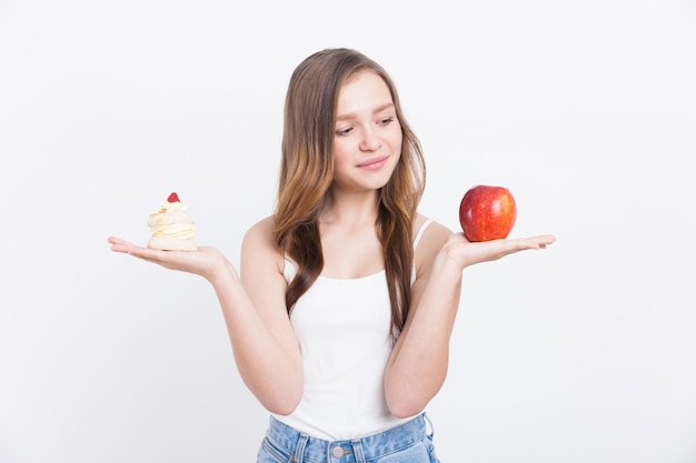 Chica en jeans con manzana y cupcake.