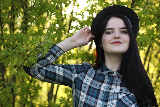 Una chica con jeans y sombrero viaja el verano en el campoxA