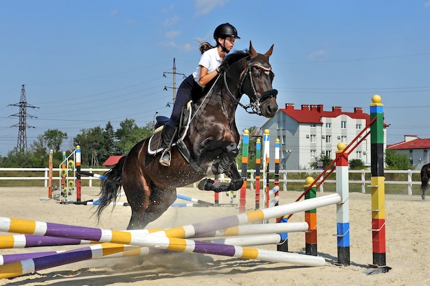 Chica jockey en la granja con su caballo