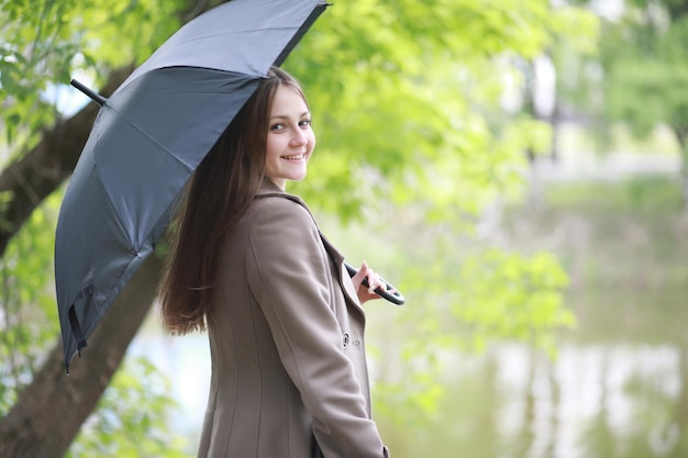 Chica joven en un abrigo en un parque de primavera