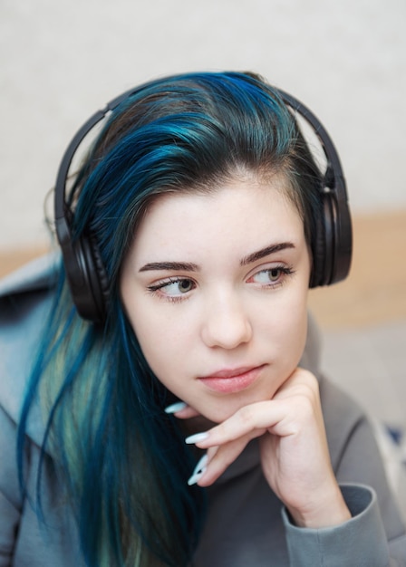 Chica joven adolescente con cabello azul y auriculares