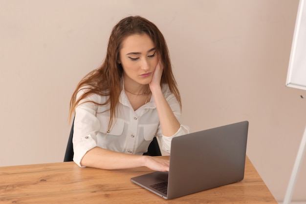 Chica joven adolescente está capacitada usando una computadora portátil