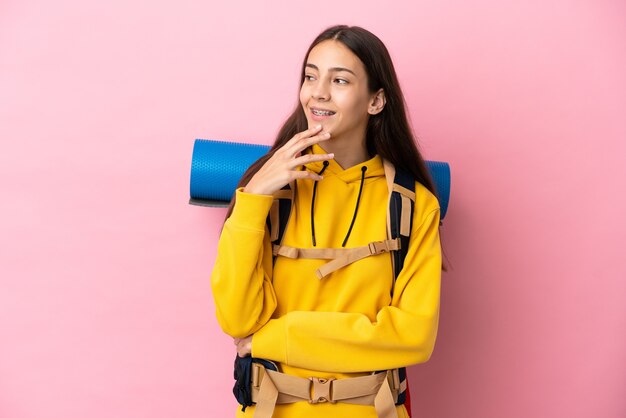 Chica joven alpinista con una mochila grande aislada