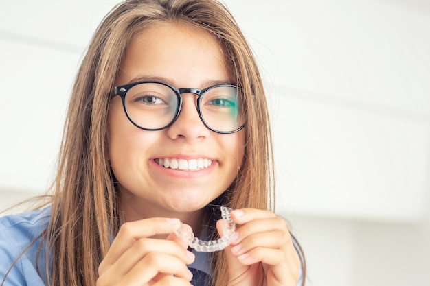 Chica joven con aparatos dentales invisibles.