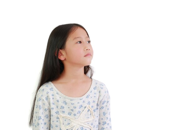 Chica joven asiática mirando hacia arriba con espacio de copia sobre fondo blanco.