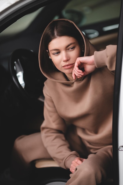 Chica joven atractiva conduciendo un coche La chica sale del coche