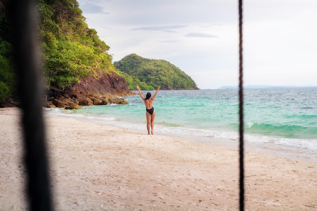 Chica joven y atractiva relajándose en una playa tropical con arena blanca y agua clara