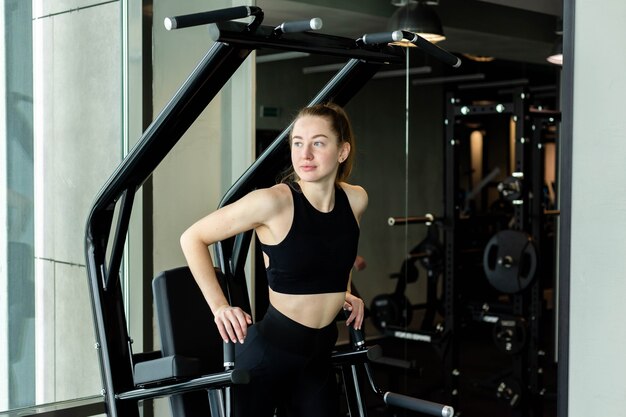 Chica joven atractiva en ropa deportiva en un concepto deportivo de club de fitness