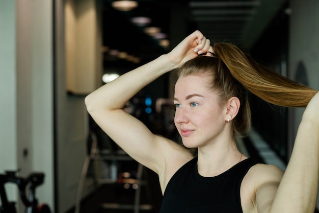 Chica joven atractiva en ropa deportiva en un concepto deportivo de club de fitness