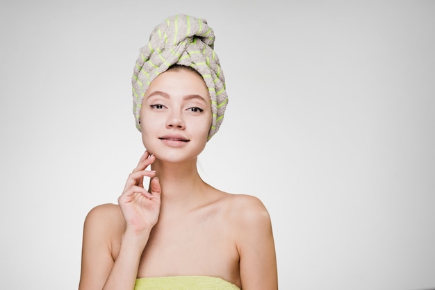 Chica joven atractiva con una toalla en la cabeza disfrutando de un spa