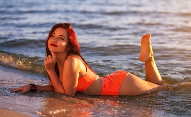 Chica joven atractiva en traje de baño en la playa