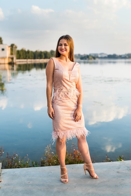 Chica joven atractiva en vestido de verano posando al aire libre