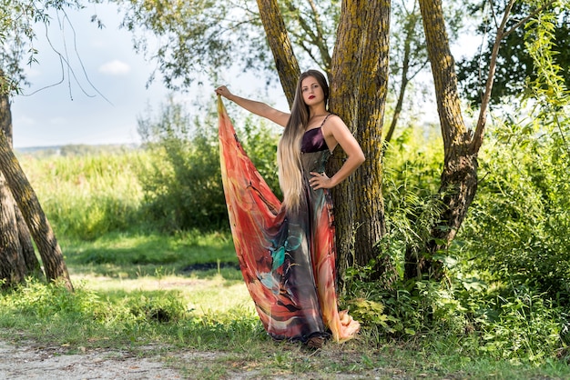 Chica joven atractiva en vestido de verano posando al aire libre